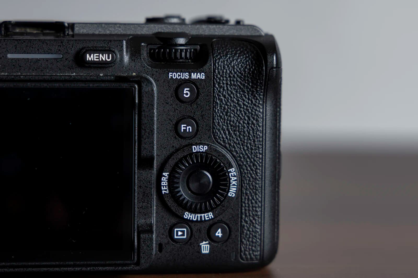 Back of a mirrorless camera showing the menu, Fn and focus magnifier buttons