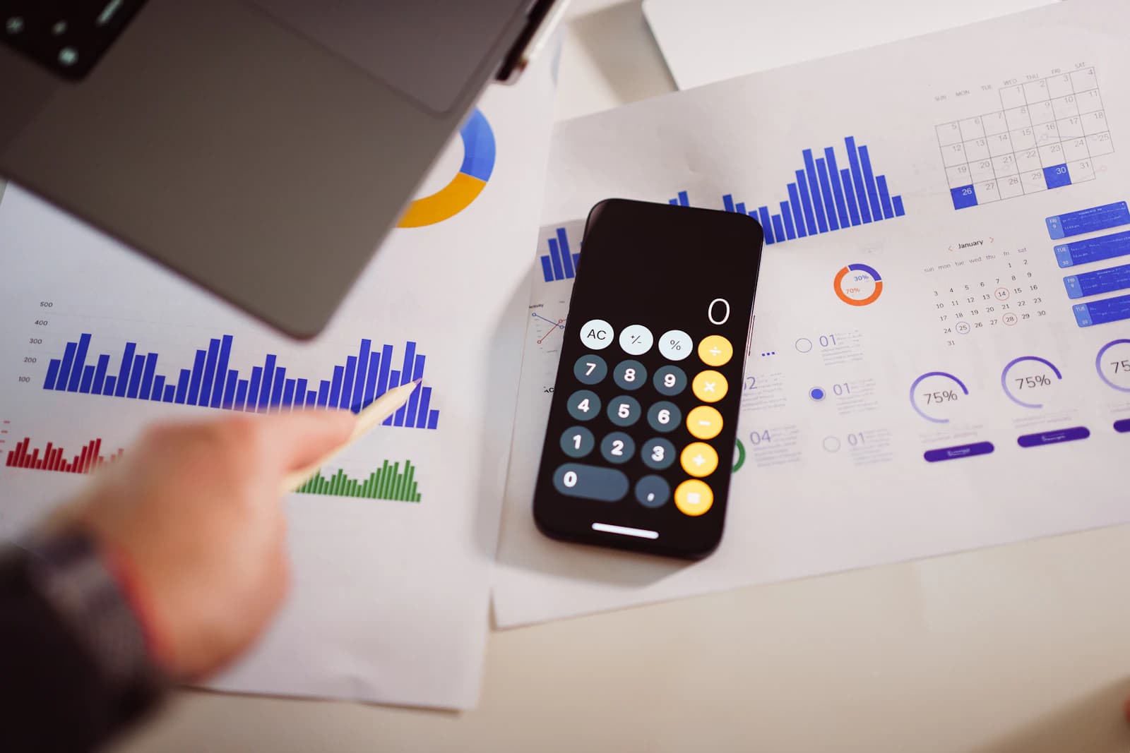Smartphone calculator on top of printed charts and graphs