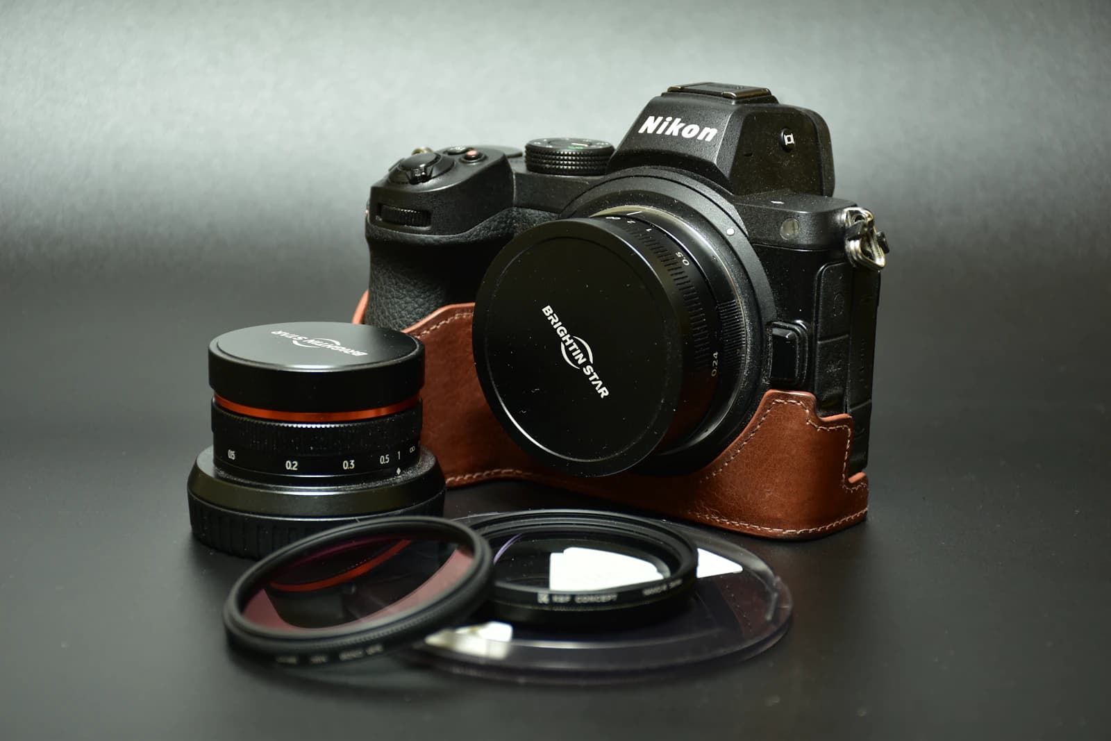 Mirrorless camera with lenses and filters on a dark surface