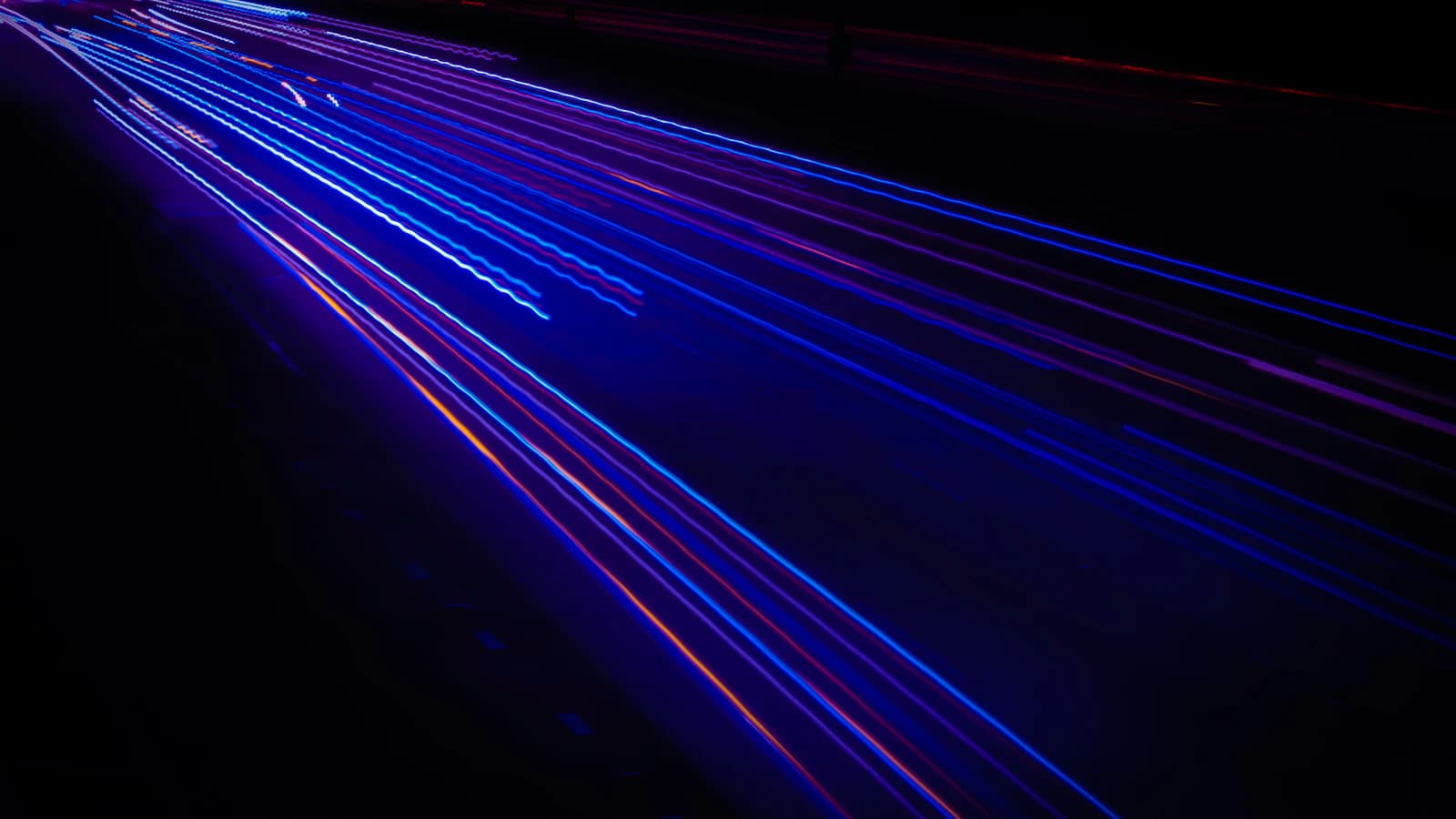 Blue light streaks cutting diagonally across a black background
