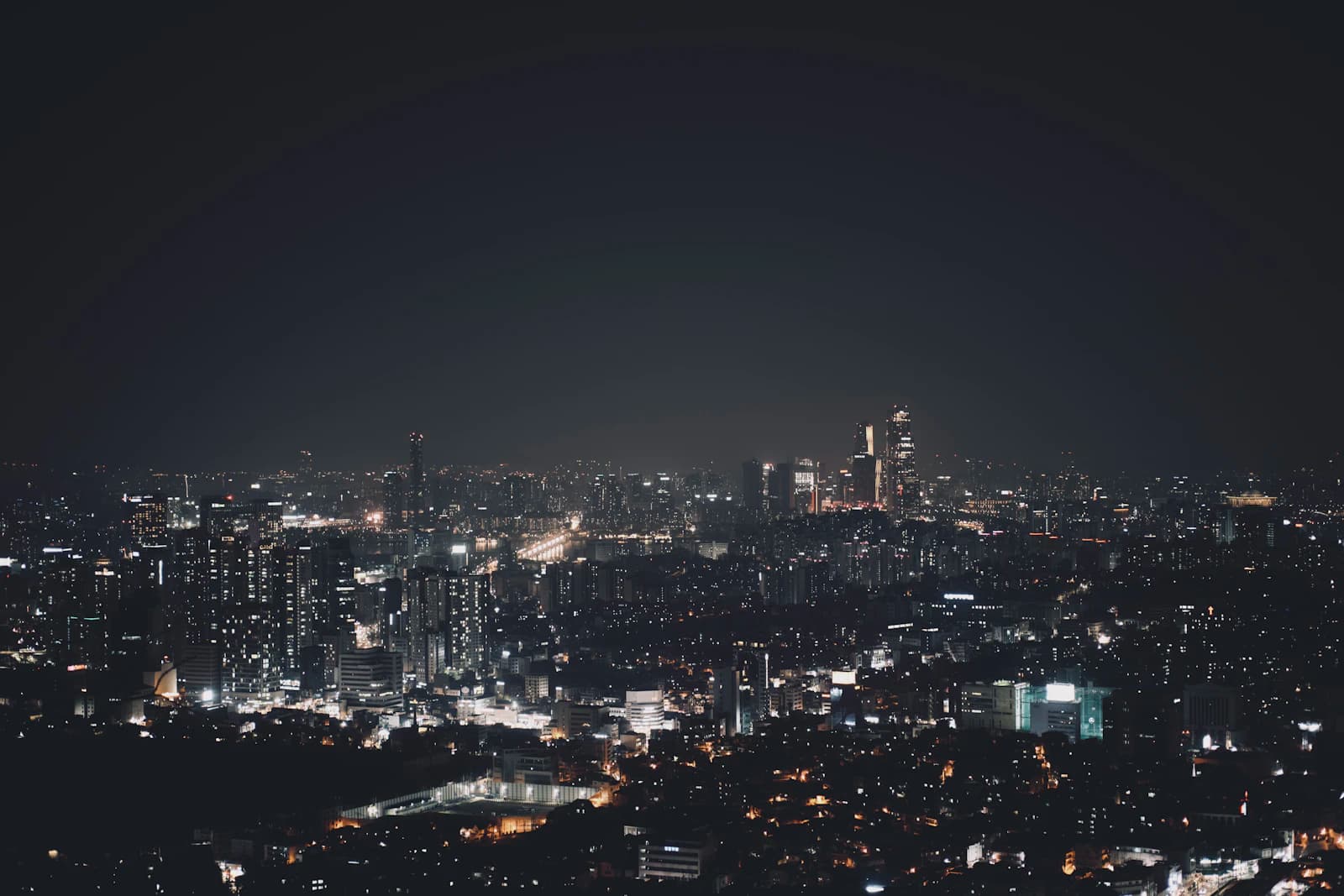 Night view of a city with glittering lights under a dark sky