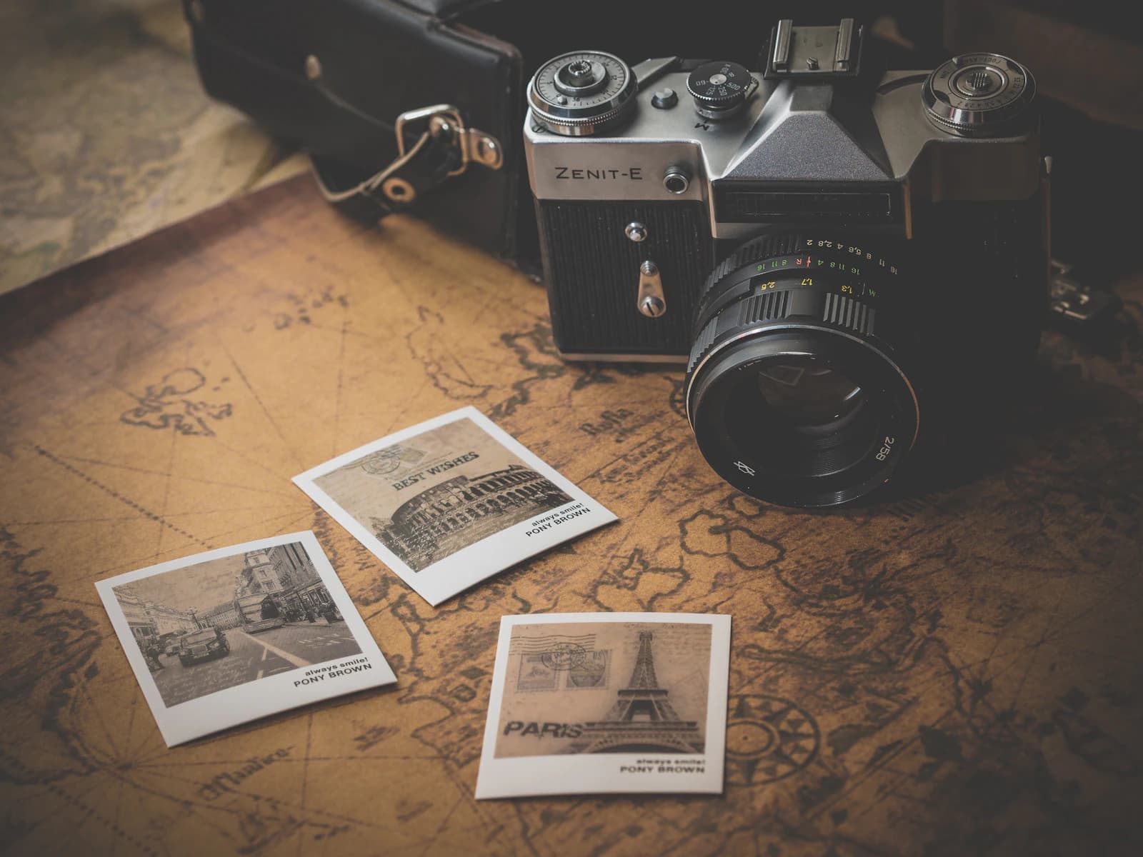 Escena vintage con una cámara de carrete y fotos instantáneas sobre un mapa