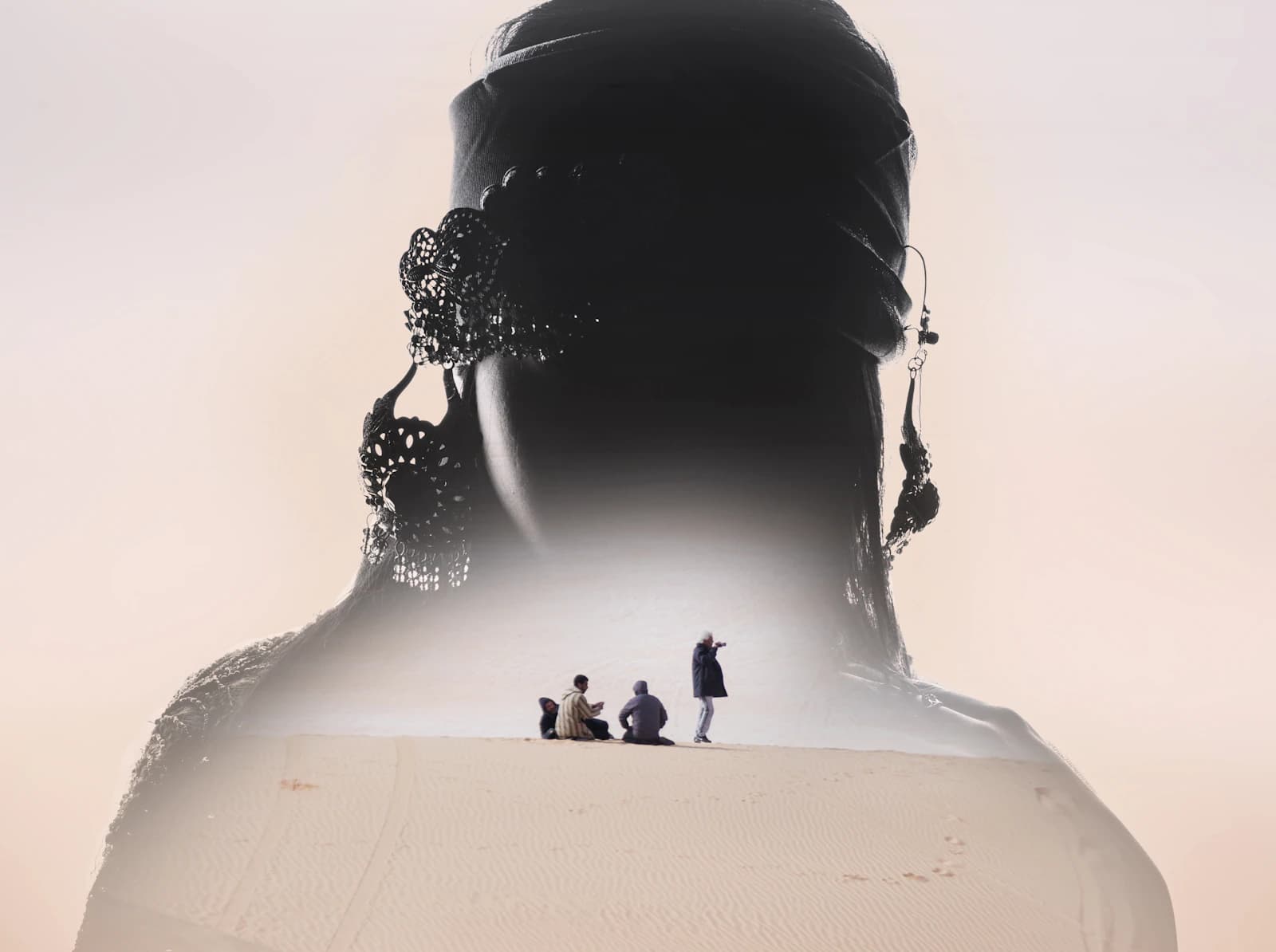 Double-exposure image of a person's silhouette containing small figures sitting in a desert
