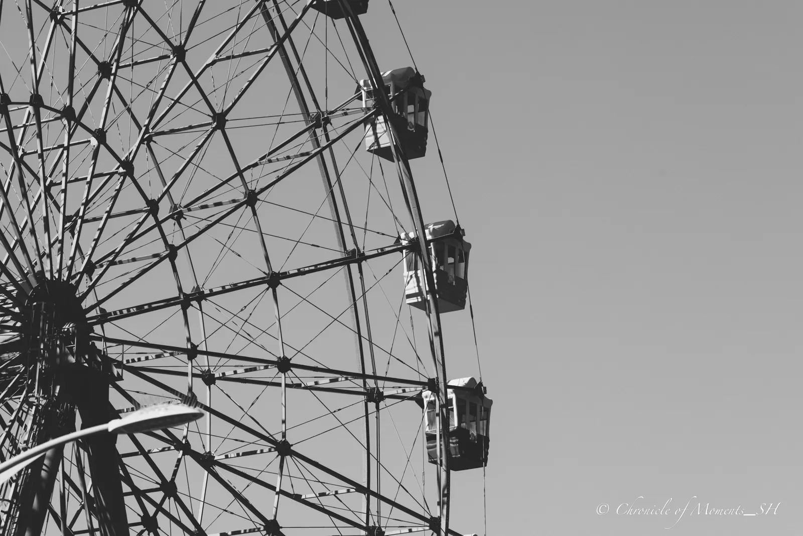 Black-and-white close crop of a ferris wheel